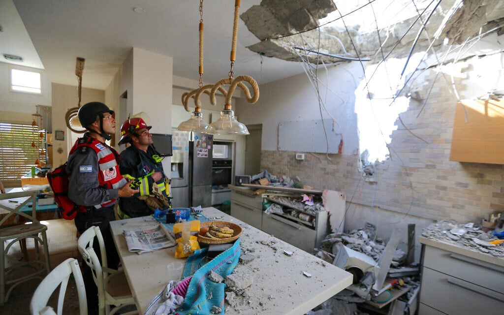 Israeli rescue forces at a home in the southern coastal city of Ashkelon that was hit by a rocket fired by Palestinian terrorists in the Gaza Strip, on May 16, 2021. (Edi Israel/Flash90)