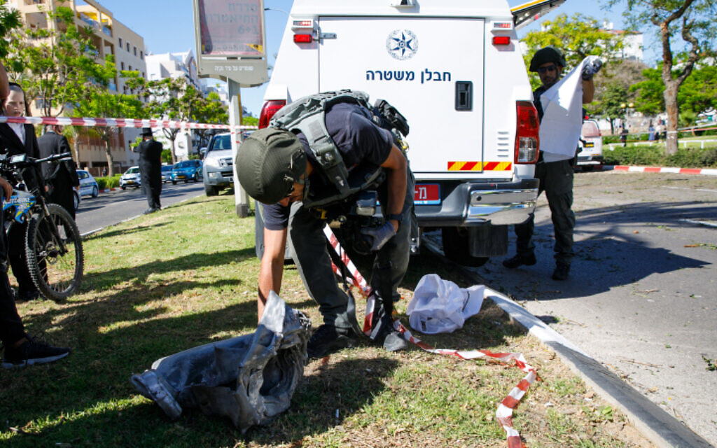 Security forces at the scene where a fragment of a rocket fired from the Gaza Strip landed in the southern Israeli city of Ashdod, on May 19, 2021 (Flash90)