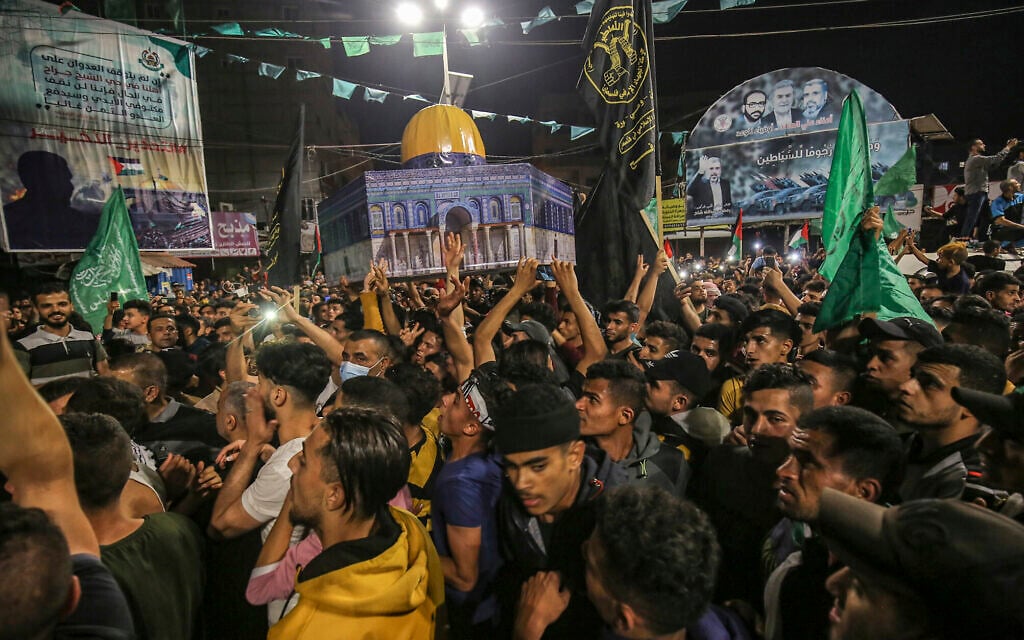 Palestinians celebrate in the streets following a ceasefire brokered by Egypt between Israel and the ruling Hamas terror group in Khan Yunis, in the southern Gaza Strip, on May 21, 2021 (Abed Rahim Khatib/Flash90)
