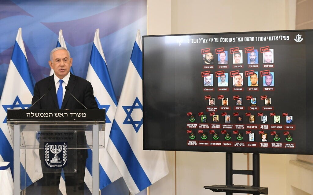 Prime Minister Benjamin Netanyahu gives a statement at a press conference after the Gaza ceasefire, Tel Aviv, May 21, 2021. At his side is a screen showing Gaza terror commanders killed in Operation Guardian of the Walls (Amos Ben Gershom/GPO)