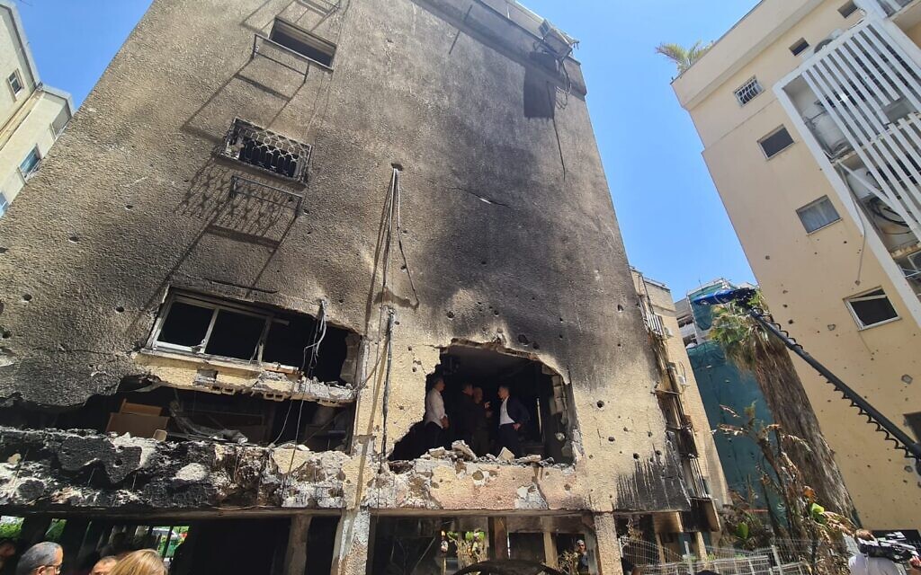 German Foreign Minister Heiko Maas tours a Petah Tikva building hit by Hamas rocket fire, along with Foreign Minister Gabi Ashkenazi and head of the IDF Home Front Command, Ori Gordin, May 20, 2021 (Foreign Ministry)
