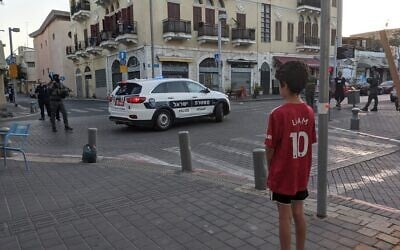 Illustrative: A child looks at local police forces in north Jaffa, May 16, 2021. (Elie Bleier/Times of Israel)