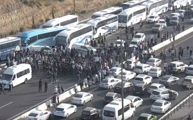Arab Israelis block traffic on Route 1 after the buses they were traveling on were stopped en route to Jerusalem, amid rising violence in the city, on May 8, 2021. (Screen capture) Arab Israelis block traffic on Route 1 after the buses they were traveling on were stopped en route to Jerusalem, amid rising violence in the city, on May 8, 2021. (Screen capture)
