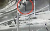 In security video released by the Israel Defense Forces, a Palestinian woman can be seen firing toward the entrance to the West Bank settlement of Kiryat Arba on May 19, 2021. (Screen capture)