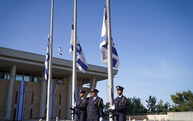 The Knesset Guard lowers Israeli flags to half-staff outside the Knesset in Jerusalem as a national day of mourning begins for victims of the Meron disaster, May 2, 2021. (Noam Moskowitz/Knesset) The Knesset Guard lowers Israeli flags to half-staff outside the Knesset in Jerusalem as a national day of mourning begins for victims of the Meron disaster, May 2, 2021. (Noam Moskowitz/Knesset)
