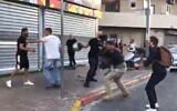 Reporters for the Kan public broadcaster are beaten in the Tikva neighborhood of Tel Aviv, May 13 , 2021 (Screen grab/Twitter)