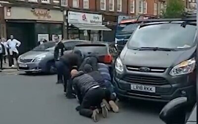 People restrain a man accused of attacking an ultra-Orthodox Jew in London on May 21, 2021 (Screencapture/YouTube)