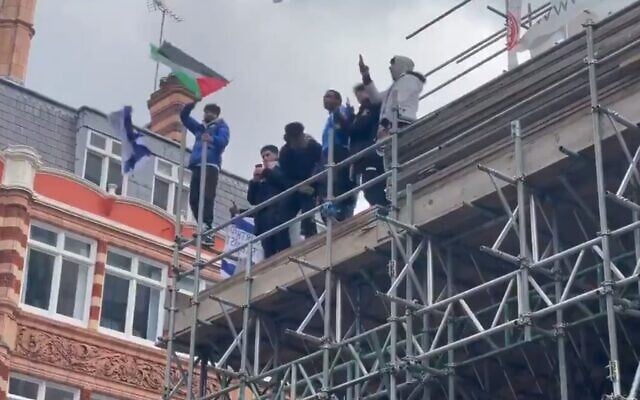 Israeli flags are ripped up and thrown from a building during a protest in London, May 15, 2021 (Screen grab/Twitter) Israeli flags are ripped up and thrown from a building during a protest in London, May 15, 2021 (Screen grab/Twitter)