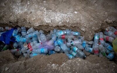 Empty plastic bottles lie strewn on a Dead Sea beach, November 5, 2020. (Yonatan Sindel/Flash90)