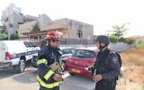 Fire service officials outside an Ashkelon synagogue hit by a rocket, May 16, 2021 (National Fire and Rescue Authority)
