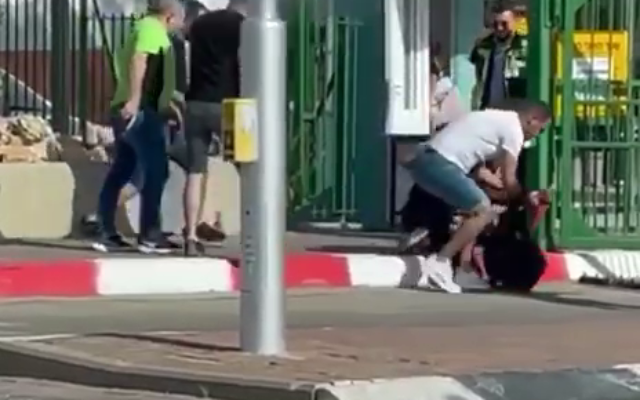 People attempt to subdue an assailant with a knife outside the Soroka Medical Center in Beersheba on May 11, 2021. (Screenshot) People attempt to subdue an assailant with a knife outside the Soroka Medical Center in Beersheba on May 11, 2021. (Screenshot)