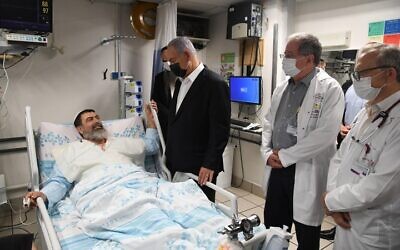 Prime Minister Benjamin Netanyahu visits a man injured in the Mount Meron disaster, at Haifa's Rambam Medical Center, May 2, 2021. (Courtesy)