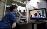 An Iranian vendor watches candidate Saeed Jalili speaking during the first televised debate between Iran presidential candidates, at a shop in Tehran on June 5, 2021. (AFP)