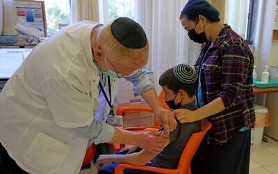 A young teen receives a dose of the Pfizer-BioNTech Covid-19 vaccine at the Misgav Ladach hospital in Jerusalem on June 6, 2021, as Israel begins its coronavirus vaccination campaign for 12- to 15-year-olds. (Menahem KAHANA/AFP)