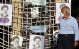 Illustrative: A supporter of Iranian presidential candidate Ebrahim Raisi walks next to his posters during an election campaign rally in the capital Tehran, on June 10, 2021. (STR / AFP)