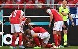 Denmark players help Denmark's midfielder Christian Eriksen after he collapsed before the medics arrive during the UEFA EURO 2020 Group B football match between Denmark and Finland at the Parken Stadium in Copenhagen on June 12, 2021. (Jonathan NACKSTRAND / various sources / AFP)