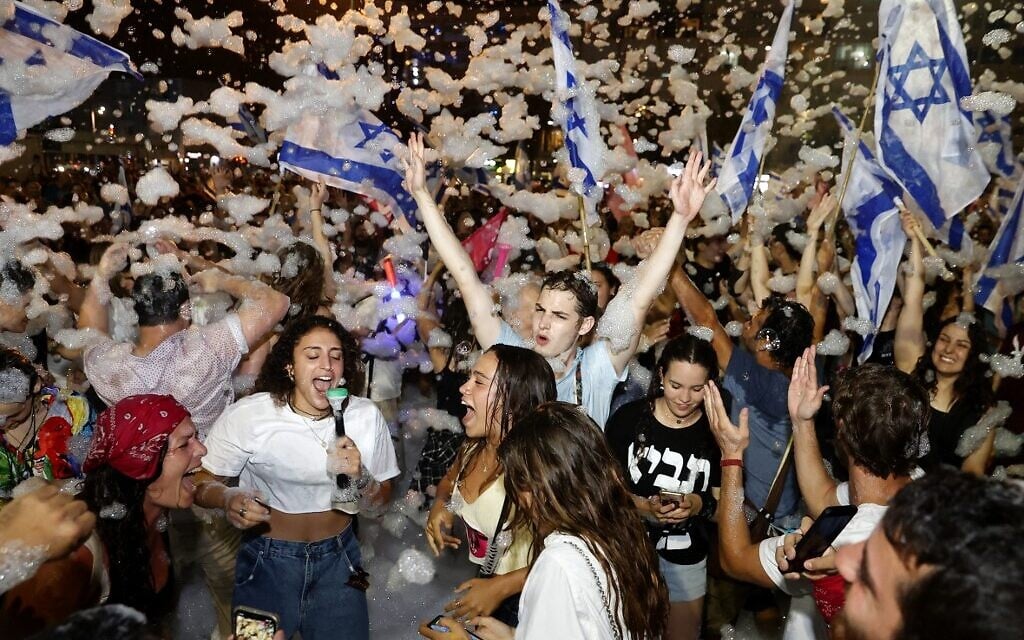 Israeli demonstrators celebrate the new government in the coastal city of Tel Aviv on June 13, 2021.  (JACK GUEZ / AFP)