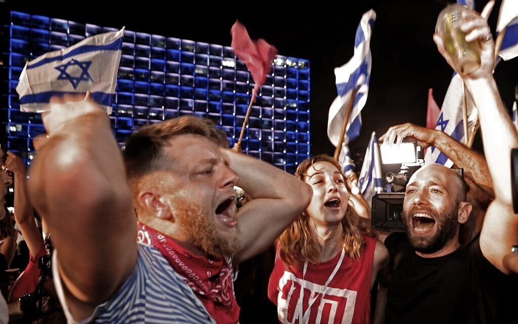 Israeli demonstrators celebrate Netanyahu's fall from power in Tel Aviv on June 13, 2021. (JACK GUEZ / AFP)