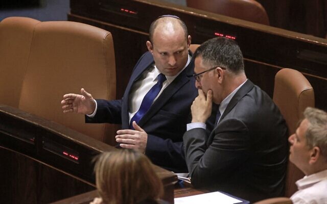 Prime Minister Naftali Bennett (left) speaks with Justice Minister Gideon Sa'ar in the Knesset on June 16, 2021. (Menahem Kahana / AFP) Prime Minister Naftali Bennett (left) speaks with Justice Minister Gideon Sa'ar in the Knesset on June 16, 2021. (Menahem Kahana / AFP)