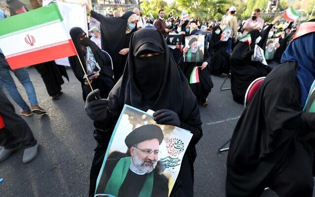 A supporter of Iranian ultraconservative presidential candidate Ebrahim Raisi carries a portrait and waves a national flag during a rally in the capital Tehran, on June 16, 2021, ahead of the June 18 presidential election (ATTA KENARE / AFP) A supporter of Iranian ultraconservative presidential candidate Ebrahim Raisi carries a portrait and waves a national flag during a rally in the capital Tehran, on June 16, 2021, ahead of the June 18 presidential election (ATTA KENARE / AFP)