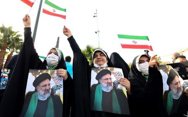 Supporters of Iranian ultraconservative presidential candidate Ebrahim Raisi carry posters bearing his portrait and wave national flags as they attend a rally in the capital Tehran, on June 16, 2021, ahead of the Islamic republic's June 18 presidential election. (Photo by ATTA KENARE / AFP) Supporters of Iranian ultraconservative presidential candidate Ebrahim Raisi carry posters bearing his portrait and wave national flags as they attend a rally in the capital Tehran, on June 16, 2021, ahead of the Islamic republic's June 18 presidential election. (Photo by ATTA KENARE / AFP)