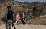 Israelis march with a national flag along a hillside near the settlement of Bat Ayin in the West Bank on June 21, 2021, as right-wing activists and settler leaders hold 14 simultaneous marches to stop 'illegal Arab control' in Area C. (Emmanuel DUNAND / AFP)