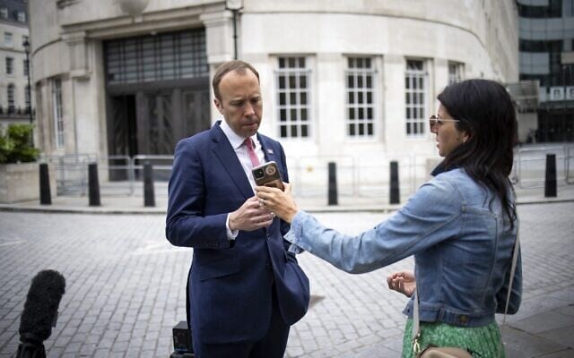 Britain's Health Secretary Matt Hancock (L), looks at the phone of his aide Gina Coladangelo as they leave the BBC in central London on June 6, 2021 (Tolga Akmen / AFP) Britain's Health Secretary Matt Hancock (L), looks at the phone of his aide Gina Coladangelo as they leave the BBC in central London on June 6, 2021 (Tolga Akmen / AFP)