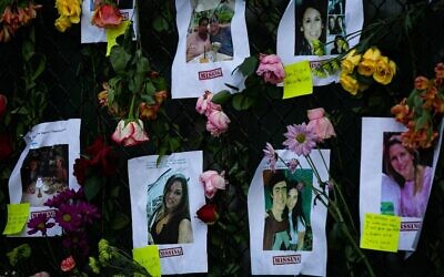 Photos of missing residents are posted at a makeshift memorial at the site of a collapsed building in Surfside, Florida, north of Miami Beach, on June 26, 2021.(Andrea SARCOS/AFP)