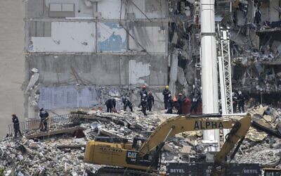 Members of the South Florida Urban Search and Rescue team look for possible survivors in the partially collapsed 12-story Champlain Towers South condo building on June 26, 2021 in Surfside, Florida. Over 150 people are being reported as missing as search-and-rescue efforts continue with rescue crews from across Miami-Dade and Broward counties. (Joe Raedle/Getty Images/AFP)