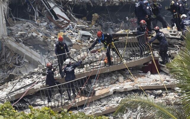 Members of the South Florida Urban Search and Rescue team look for possible survivors in the partially collapsed 12-story Champlain Towers South condo building on June 26, 2021 in Surfside, Florida. (Joe Raedle/Getty Images/AFP) Members of the South Florida Urban Search and Rescue team look for possible survivors in the partially collapsed 12-story Champlain Towers South condo building on June 26, 2021 in Surfside, Florida. (Joe Raedle/Getty Images/AFP)