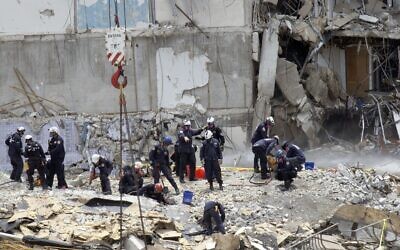 Members of the South Florida Urban Search and Rescue team look for possible survivors in the partially collapsed 12-story Champlain Towers South condo building on June 26, 2021, in Surfside, Florida. (Joe Raedle/Getty Images/AFP)