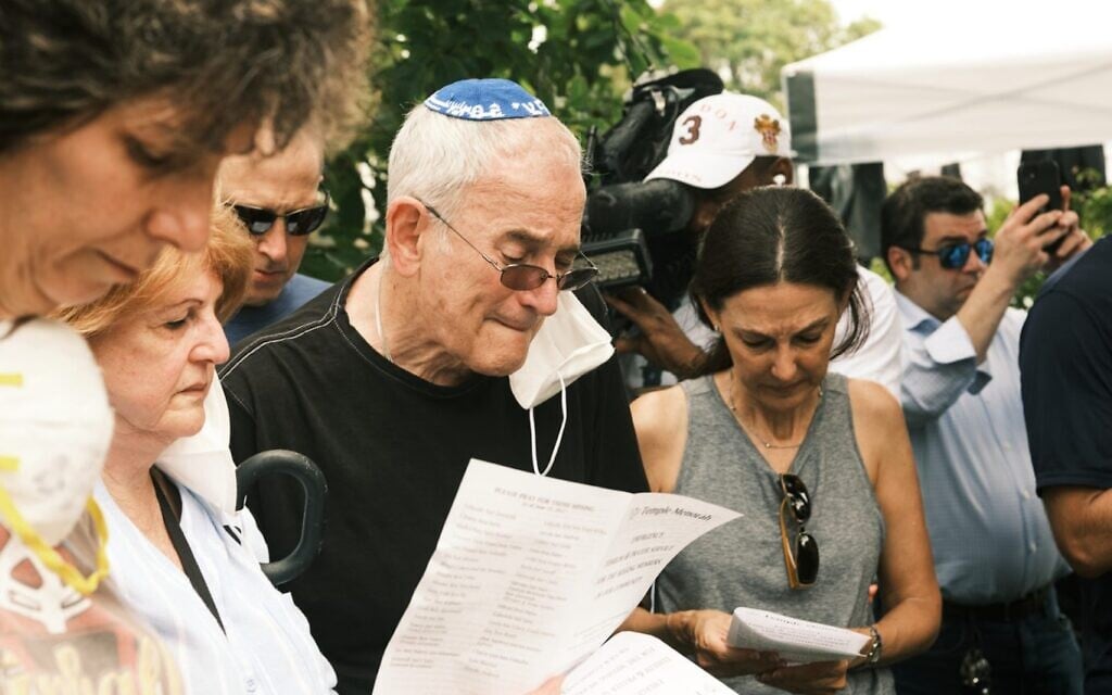 Rabbi Eliot Pearlson, in kippah, leads a psalm reading as he speaks to members of his congregation in the wake of the collapse of the Champlain Towers in Surfside, Fla., June 25, 2021. Pearlson, who has a number of his congregates among those missing, is the rabbi at Temple Menorah just a few blocks from the collapsed condos. (Zack Wittman for The Washington Post via Getty Images via JTA) Rabbi Eliot Pearlson, in kippah, leads a psalm reading as he speaks to members of his congregation in the wake of the collapse of the Champlain Towers in Surfside, Fla., June 25, 2021. Pearlson, who has a number of his congregates among those missing, is the rabbi at Temple Menorah just a few blocks from the collapsed condos. (Zack Wittman for The Washington Post via Getty Images via JTA)