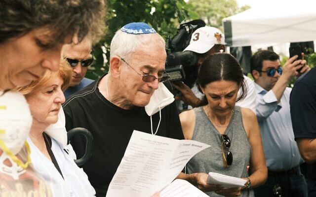 Rabbi Eliot Pearlson, in kippah, leads a psalm reading as he speaks to members of his congregation in the wake of the collapse of the Champlain Towers in Surfside, Fla., June 25, 2021. Pearlson, who has a number of his congregates among those missing, is the rabbi at Temple Menorah just a few blocks from the collapsed condos. (Zack Wittman for The Washington Post via Getty Images via JTA)