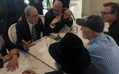 Nachman Shai, second from left, speaks to Sen. Rick Scott, in cap, at the Grand Beach Hotel in Surfside, Fla., June 27, 2021. (Ron Kampeas)
