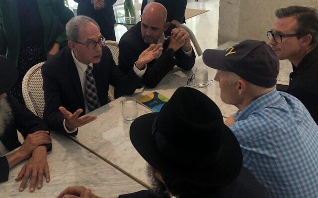 Nachman Shai, second from left, speaks to Sen. Rick Scott, in cap, at the Grand Beach Hotel in Surfside, Fla., June 27, 2021. (Ron Kampeas) Nachman Shai, second from left, speaks to Sen. Rick Scott, in cap, at the Grand Beach Hotel in Surfside, Fla., June 27, 2021. (Ron Kampeas)