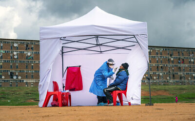 In this Wednesday, April 29, 2020 file photo, a resident from the Alexandra township gets tested for the new coronavirus, in Johannesburg, South Africa. (AP Photo/Jerome Delay, File)