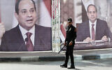 A Hamas police officer stands guards at the main square in front of large portraits of Egyptian President Abdel Fattah el-Sissi, while Hamas leaders meet with Egypt's intelligence chief Abbas Kamel, unseen, in Gaza City, May 31, 2021. (AP Photo/Adel Hana)