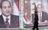 Illustrative: A Hamas police officer walks in front of large portraits of Egyptian President Abdel Fattah el-Sissi, while Hamas leaders meet with Egypt's intelligence chief Abbas Kamel in Gaza City, May 31, 2021. (Adel Hana/AP)