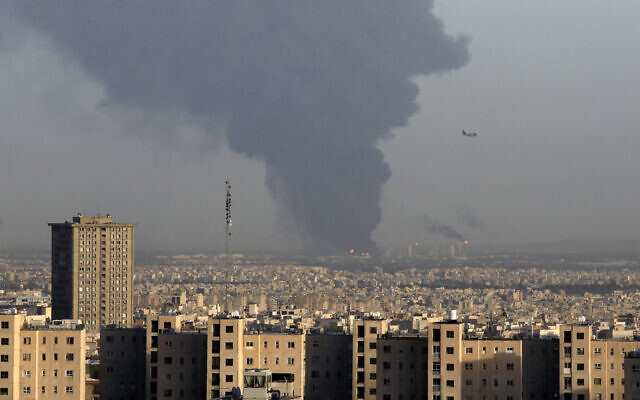 Huge smoke rises from Tehran's main oil refinery as a plane approaches Mehrabad airport south of Tehran, Iran, June 2, 2021. A massive fire broke out Wednesday night at the oil refinery serving Iran's capital, sending thick plumes of black smoke over Tehran. (AP Photo/Vahid Salemi)