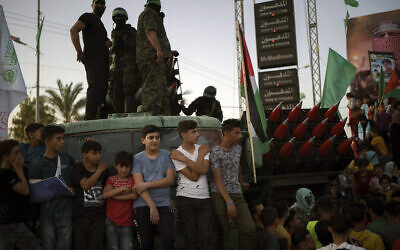 Palestinians gather as Hamas members parade at a rally just over a week after a ceasefire was reached in an 11-day war between the terror group and Israel, May 30, 2021, in Beit Lahia, northern Gaza Strip. (AP Photo/Felipe Dana)