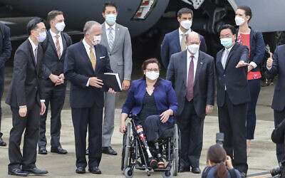 Taiwan's Foreign Minister Joseph Wu, second right, gestures as he welcomes US senators to his right Democratic Sen. Christopher Coons of Delaware, a member of the Foreign Relations Committee, Democratic Sen. Tammy Duckworth of Illinois and Republican Sen. Dan Sullivan of Alaska, members of the Armed Services Committee on their arrival at the Songshan Airport in Taipei, Taiwan on Sunday, June 6, 2021. (Pool Photo via AP)