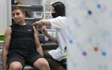 An Israeli youth receives a Pfizer-BioNTech COVID-19 vaccine in Rishon LeZion on June 6, 2021. (AP Photo/Sebastian Scheiner)