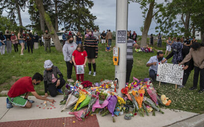 People attend a memorial at the location where a family of five was hit by a driver, in London, Ontario, June 7, 2021 (Brett Gundlock/The Canadian Press via AP)