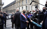 French far-right leader Marine le Pen, center, talks to media after laying a wreath during a ceremony in Paris on May 1, 2021. (AP Photo/Thibault Camus)
