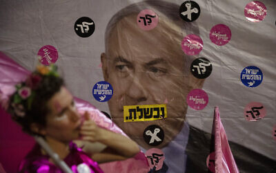 An Israeli protester wears pink during a demonstration against Israeli Prime Minister Benjamin Netanyahu outside his official residence in Jerusalem, June 12, 2021. (AP Photo/Ariel Schalit)