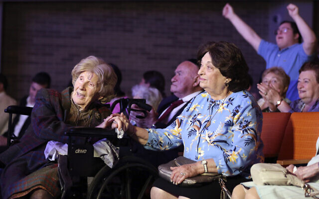 Aranka Engel, 103, left, holds the hand of fellow Holocaust survivor Jean Kurz, 81, while watching Orthodox Jewish singer Yaakov Shwekey perform at a concert honoring them and dozens of other Holocaust survivors on Monday, June 14, 2021, at the Yeshivah of Flatbush theater at Joel Braverman High School in the Brooklyn borough of New York. It was the first large gathering for New York-area Holocaust survivors after more than a year of isolation due to the coronavirus pandemic. (AP Photo/Jessie Wardarski) Aranka Engel, 103, left, holds the hand of fellow Holocaust survivor Jean Kurz, 81, while watching Orthodox Jewish singer Yaakov Shwekey perform at a concert honoring them and dozens of other Holocaust survivors on Monday, June 14, 2021, at the Yeshivah of Flatbush theater at Joel Braverman High School in the Brooklyn borough of New York. It was the first large gathering for New York-area Holocaust survivors after more than a year of isolation due to the coronavirus pandemic. (AP Photo/Jessie Wardarski)