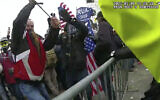 This still frame from Metropolitan Police Department body worn camera video shows Thomas Webster, in red jacket, at a barricade line at on the west front of the US Capitol on Jan. 6, 2021, in Washington (Metropolitan Police Department via AP)