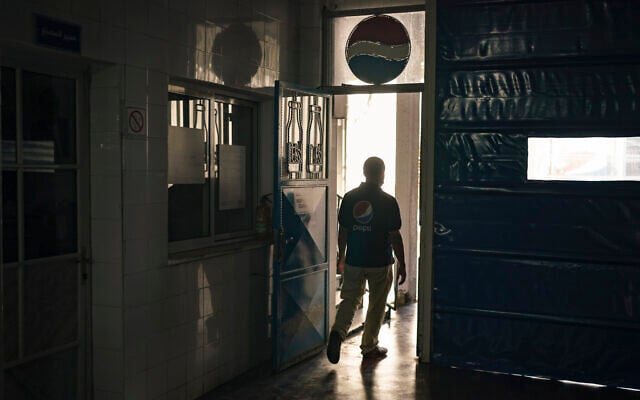 A Palestinian employee walks at the Pepsi bottling plant in Gaza City, June 21, 2021. (AP Photo/Felipe Dana) A Palestinian employee walks at the Pepsi bottling plant in Gaza City, June 21, 2021. (AP Photo/Felipe Dana)