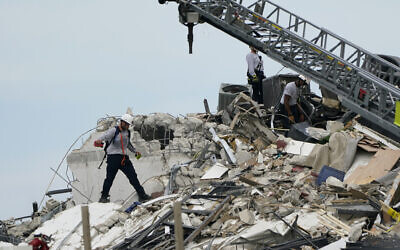Rescue worker walk among the rubble where a wing of a 12-story beachfront condo building collapsed, Thursday, June 24, 2021, in the Surfside area of Miami. (AP/Lynne Sladky)