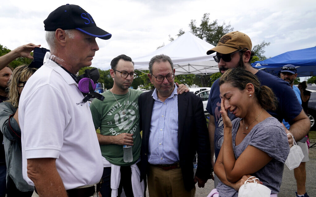 The Mayor of Surfside Charles Burkett, left, talks with Rachel Spiegel, right, who is looking for information on the Champlain Towers South Condo building, June 26, 2021, in the Surfside area of Miami. (AP Photo/Lynne Sladky)